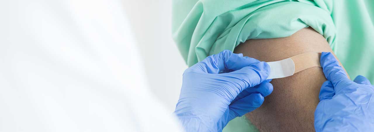 Putting band aid on arm after getting vaccines.