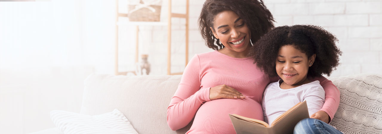 Pregnant mom reading to her daughter